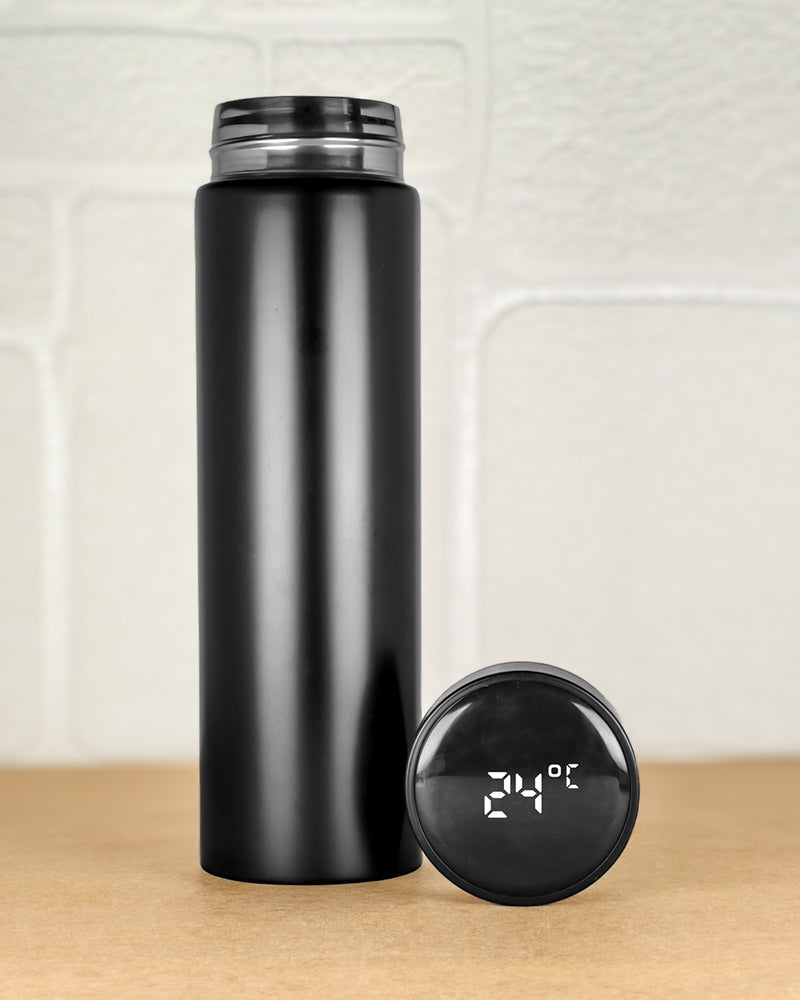 Black insulated bottle with digital temperature display on a wooden surface.