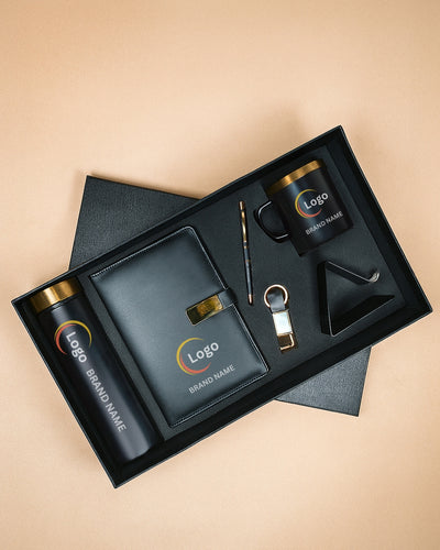 Gift set with branded items including a mug, pen, bottle, and keychain in a black box on a beige background.