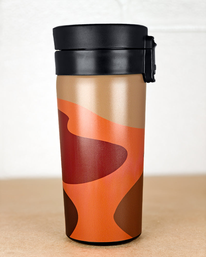 Travel mug with orange and brown abstract design on a white background