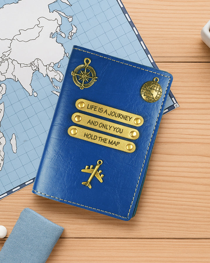 Blue passport holder with gold text and symbols on a wooden surface with a world map in the background.