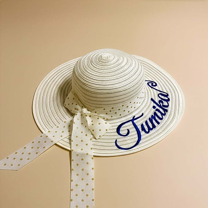 Beige straw hat with a polka dot ribbon and &
