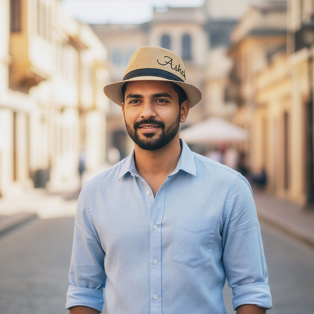 Man wearing a light blue shirt and beige hat with 'Astrid' branding, standing on a street.