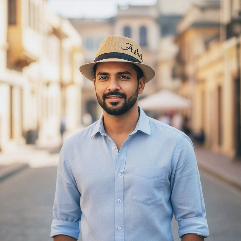 Man wearing a light blue shirt and beige hat with &