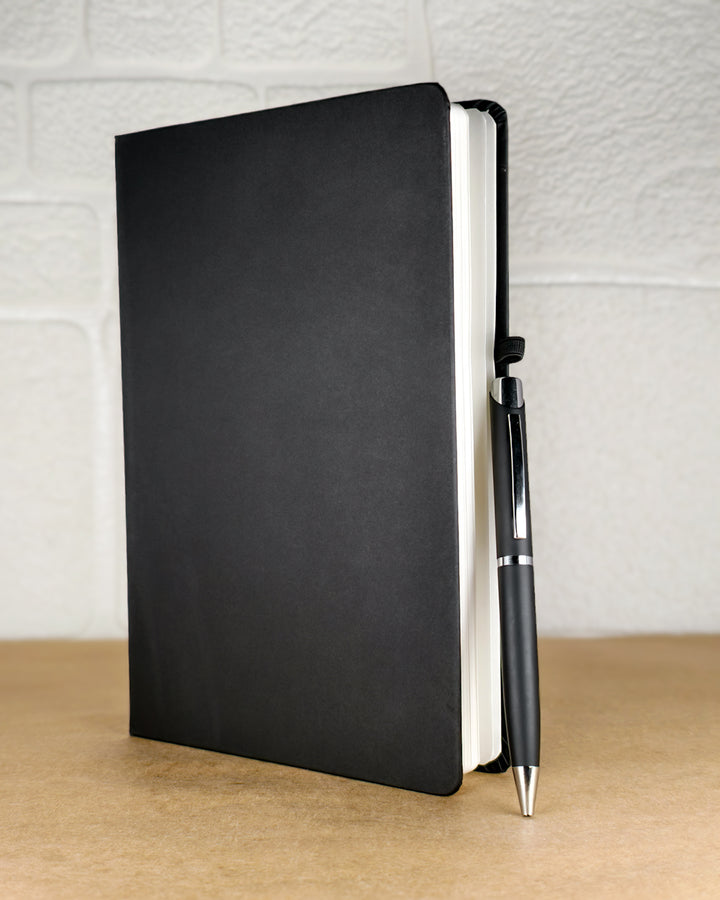 Black notebook and pen on a wooden surface with a light gray textured background