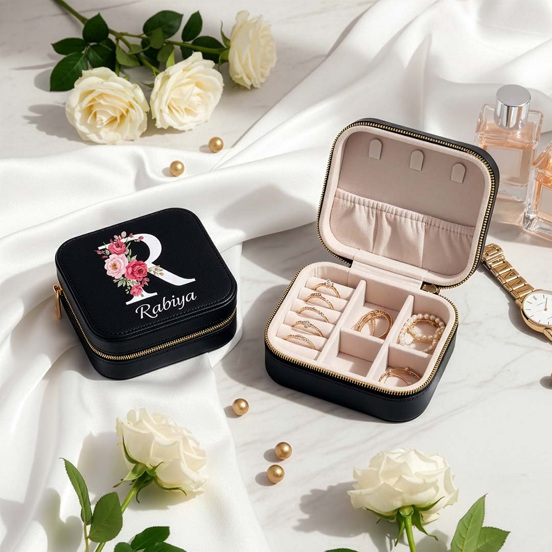Jewelry box with 'Rabiya' branding on a white fabric background with flowers and jewelry.