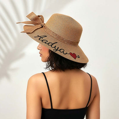 Woman wearing a straw hat with 'Maddy' and a heart design on a white background