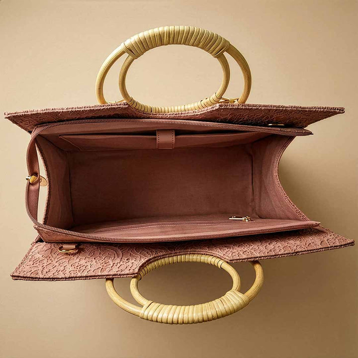Pink handbag with gold handles on a beige background