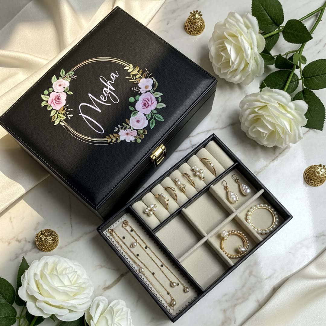 Jewelry box with floral design and jewelry on a marble surface with flowers.