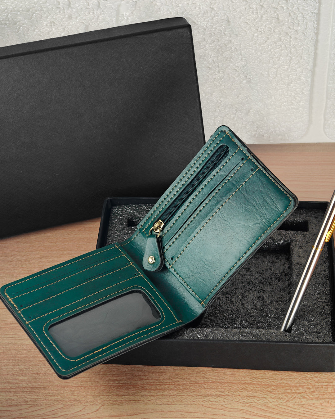 Green wallet with a pen on a wooden surface