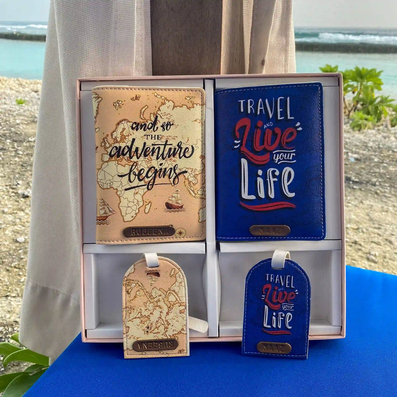 A set of passport covers and luggage tags with travel-themed prints displayed on a table with couple edition box by tpc gifts 