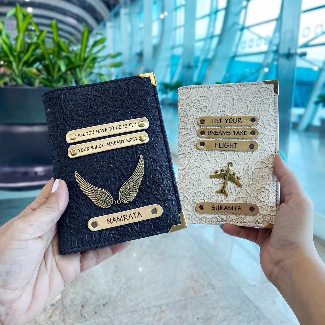 Two people holding black and white passport covers with custom text and charms, displayed in an airport setting.