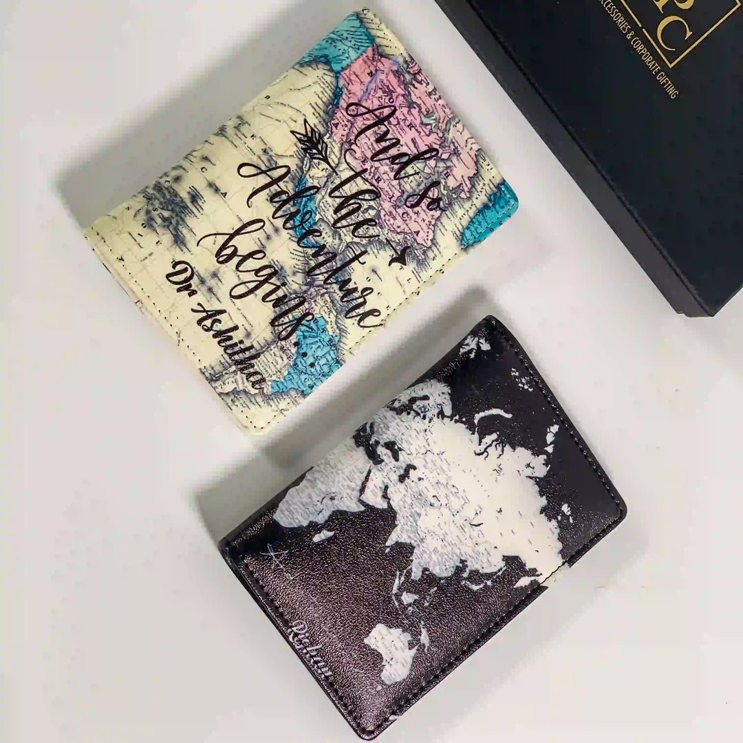 Couple print map passport covers one has a cream base with a colorful map print and cursive text; the other has a black-and-white world map print  hand by TPC Gifts. O