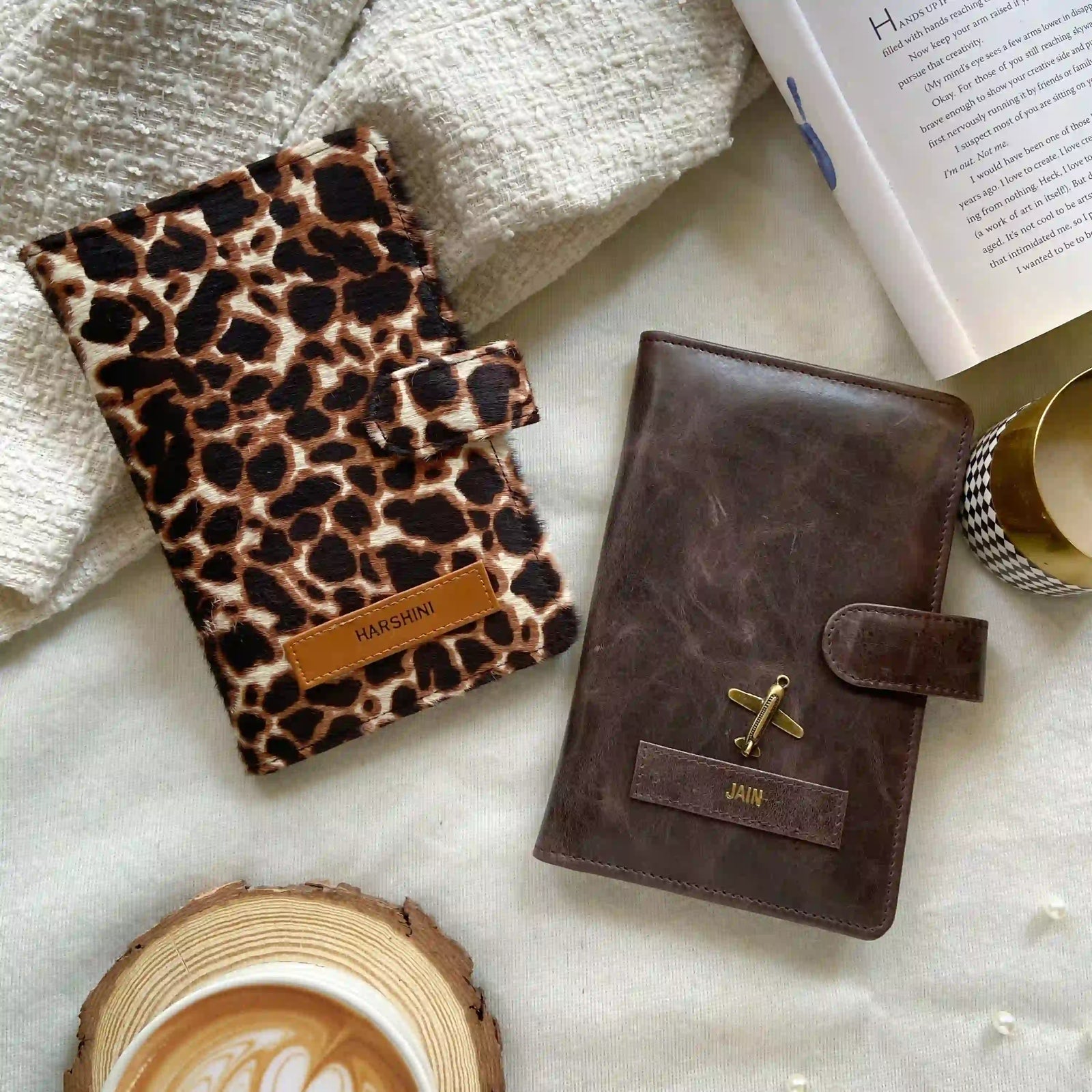 Leopard print notebook and brown leather journal on a marble surface with a coffee cup and book.