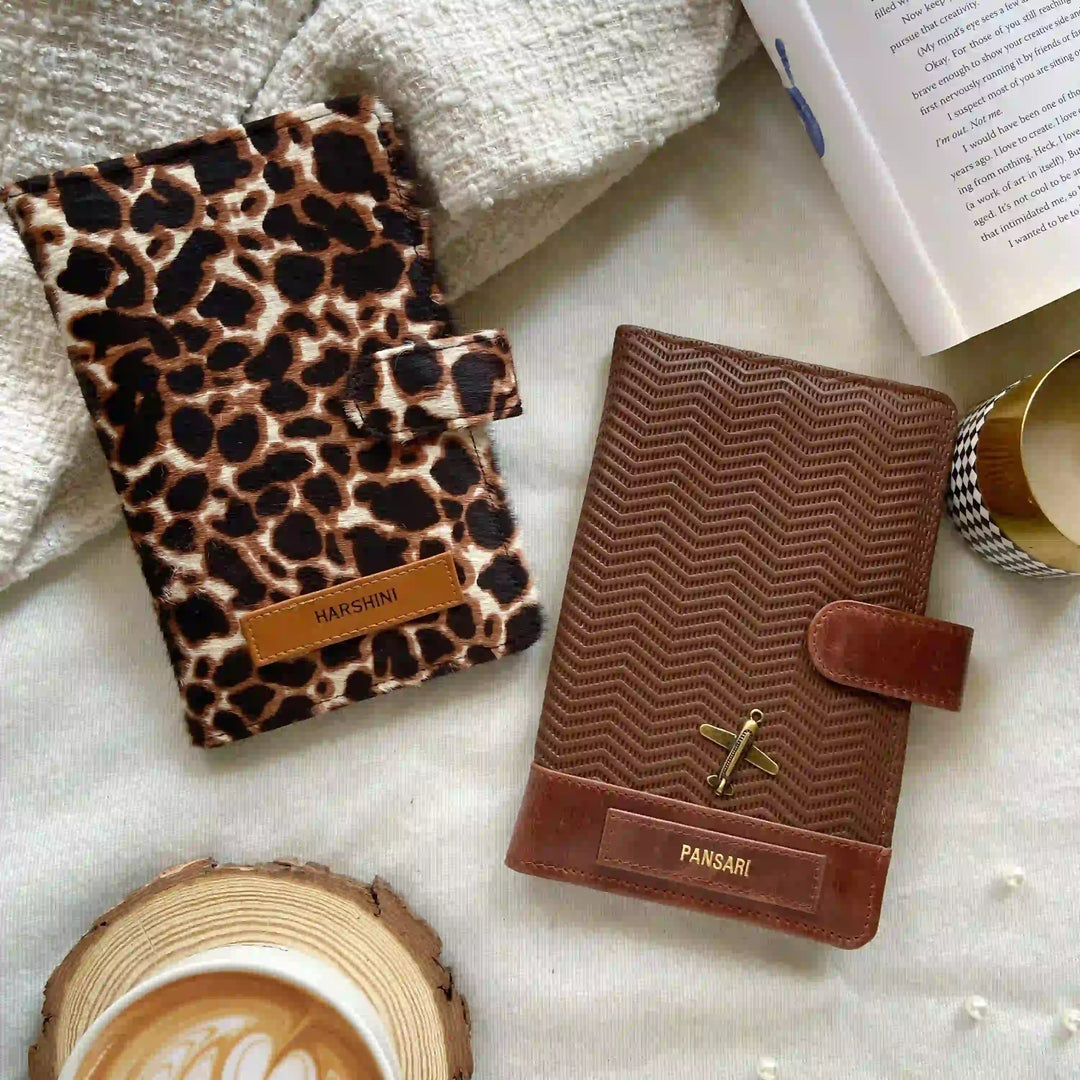 Two leather-bound books with distinctive covers on a textured surface with a cup of coffee.