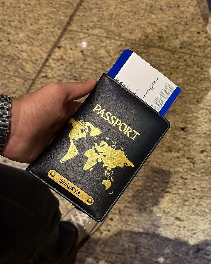 Hand holding a passport cover with a world map design at the airport by TPC Gifts