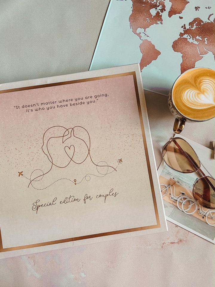 Couple Passport Cover &amp; Luggage Tag Box by TPC gifts in a flat lay position with a sunglass and a cup at the side. 