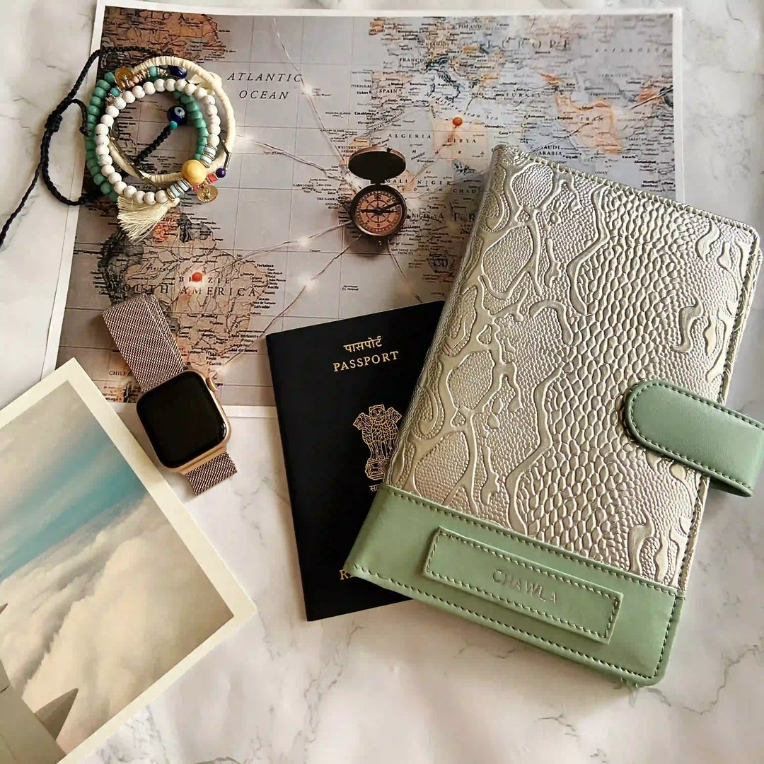 Green travel wallet with passport and watch on a world map background - TPC Gifts 