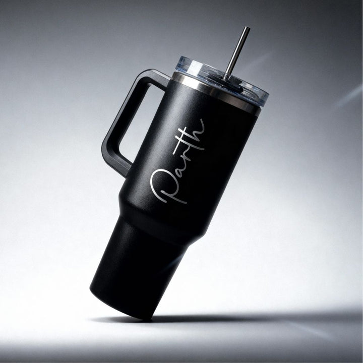 Black insulated tumbler with handle and straw lid on a gray background