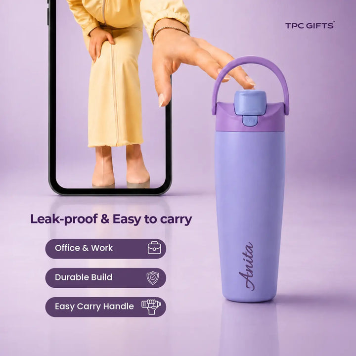 A lavender and purple insulated water bottle with a carry loop and flip spout lid, shown beside a smartphone screen displaying a person wearing matching lavender clothing. Text on the image reads &