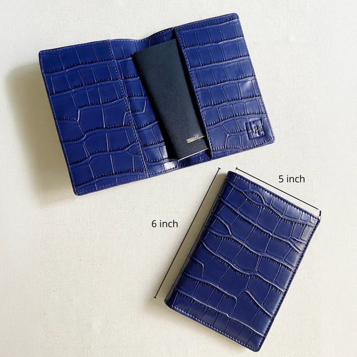 A blue crocodile-embossed leather passport cover shown open and closed on a light background, with dimension labels indicating 5 inch, 6 inch, and 6 inch measurements.