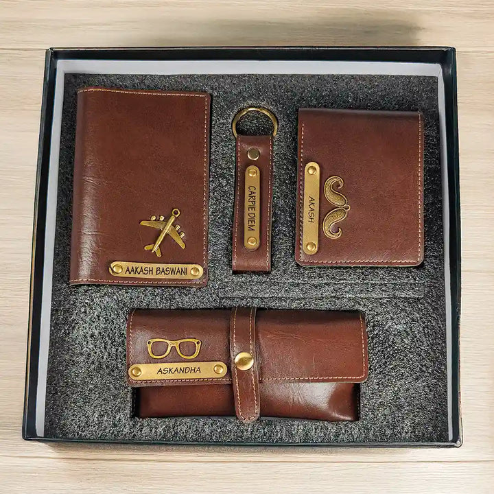 A 4-piece brown leather wallet set in a black gift box, including a main wallet, a card holder, a keychain, and a belt bag, all with gold-colored metal accents and custom names engraved.