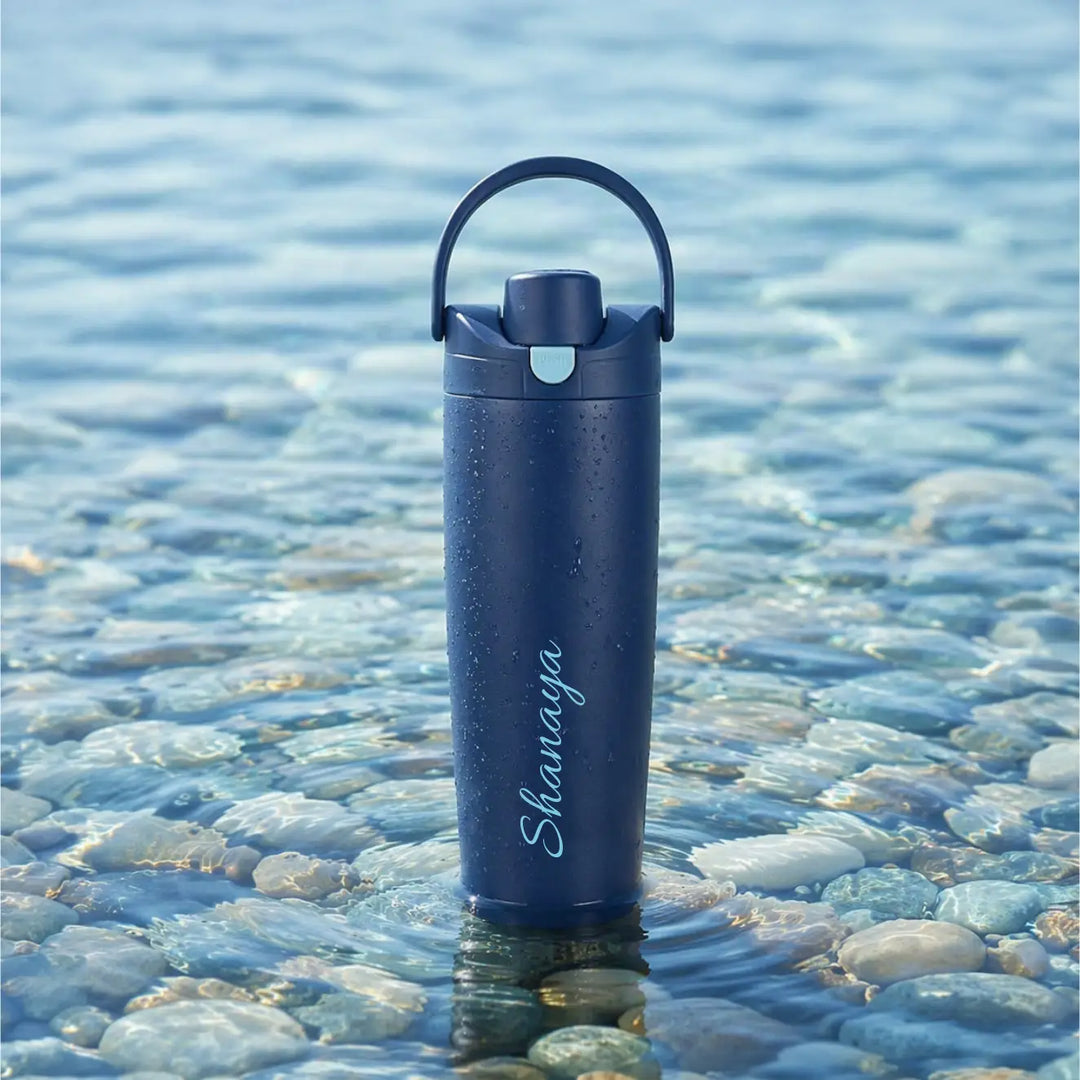 A dark navy blue insulated water bottle with a carrying loop and the brand name &