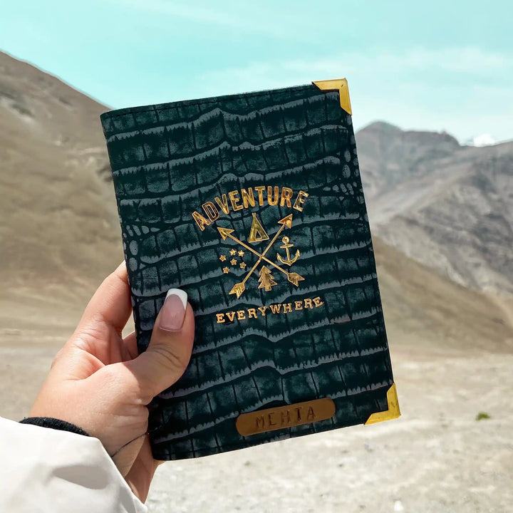 Genuine Leather passport cover by TPC Gifts a hand holding a dark vintage blue crocodile-embossed passport cover with gold foil accents and the words &