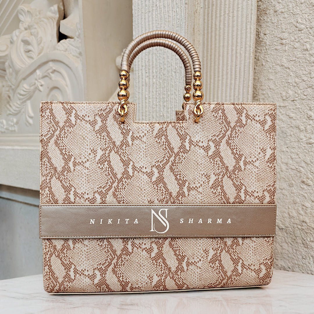 Designer personalized tote bag by TPC Gifts with snake print and gold accents on a marble surface