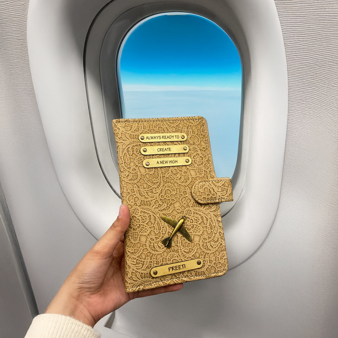 A personalized travel wallet being held by a passenger on an airplane, featuring a black leather exterior with metal accents and card slots visible through the wallet&