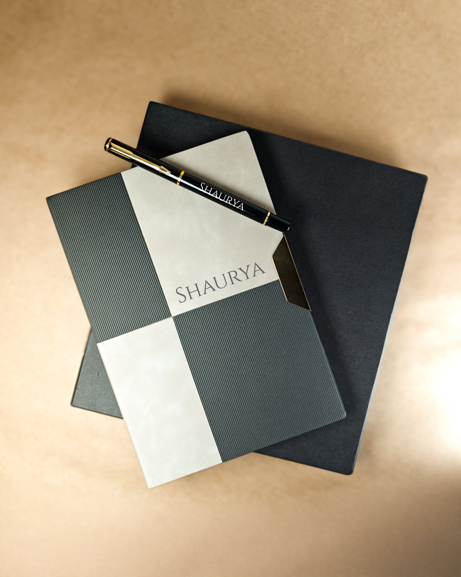 Notebook and pen set with 'SHAUURYA' branding on a beige background