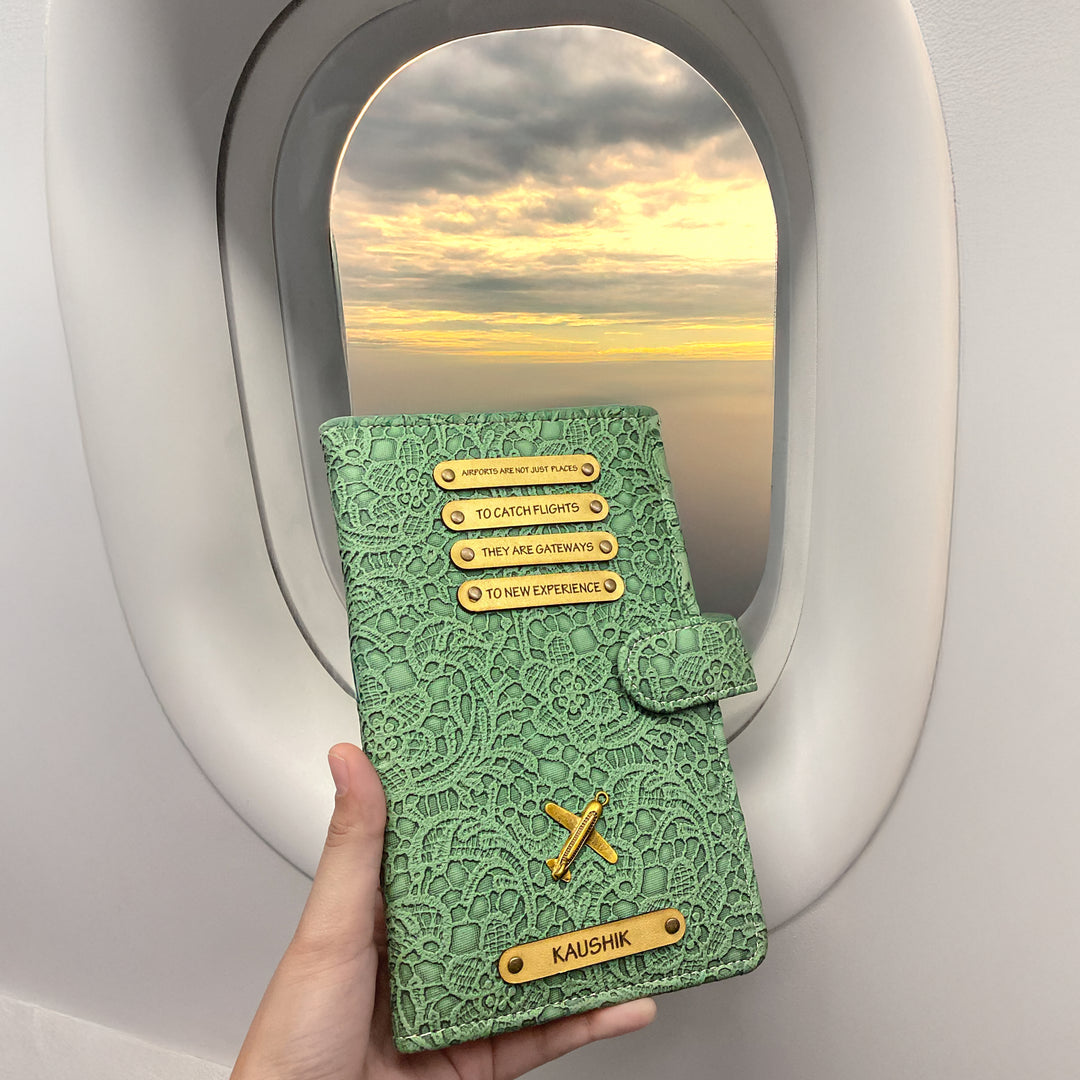 A personalized travel wallet being held by a passenger on an airplane, featuring a black leather exterior with metal accents and card slots visible through the wallet&