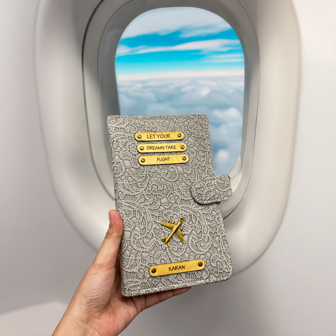 A personalized travel wallet being held by a passenger on an airplane, featuring a black leather exterior with metal accents and card slots visible through the wallet&