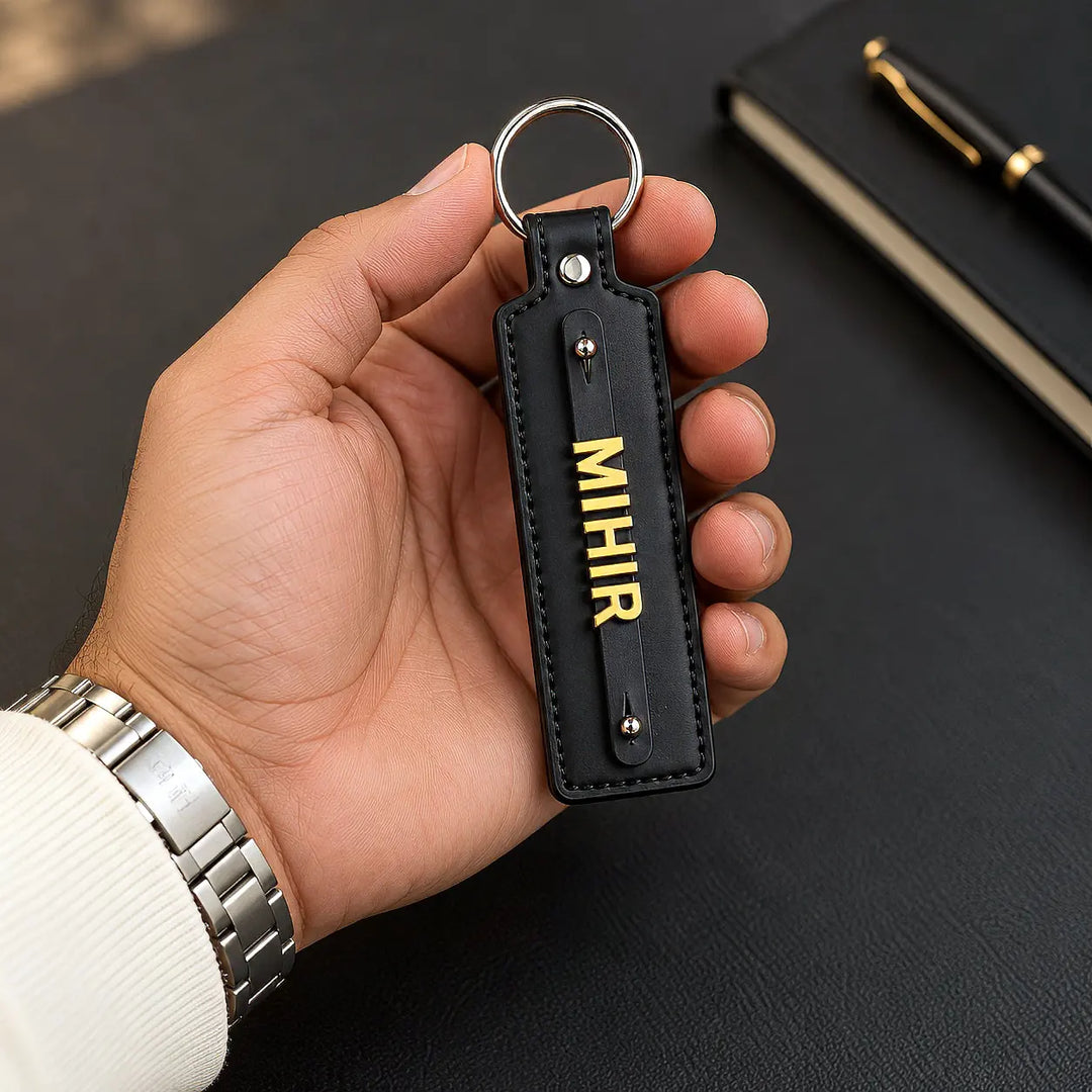 Black vegan-leather keychain with gold-tone name letters