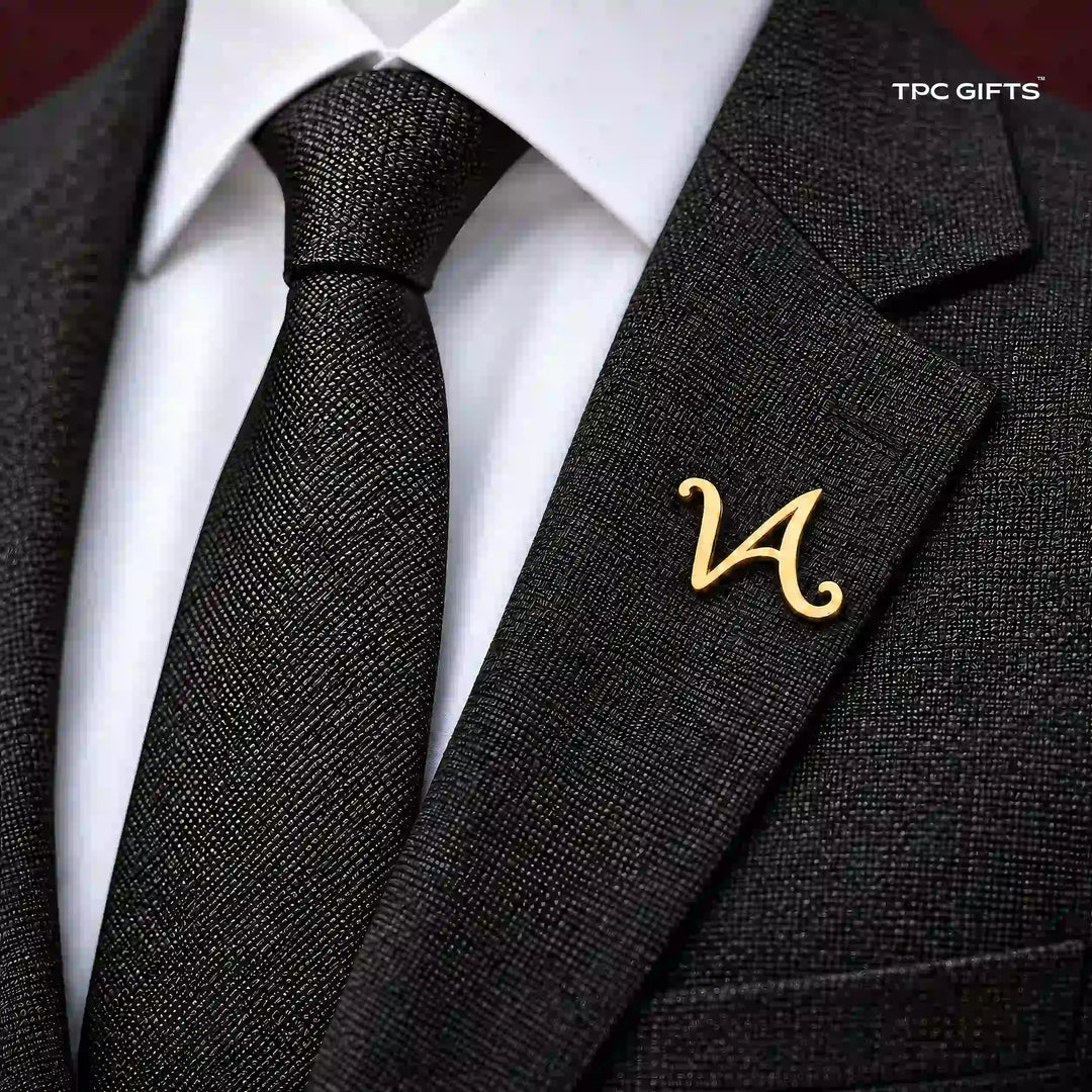 Personalised gold tone script lapel pin worn on a charcoal suit