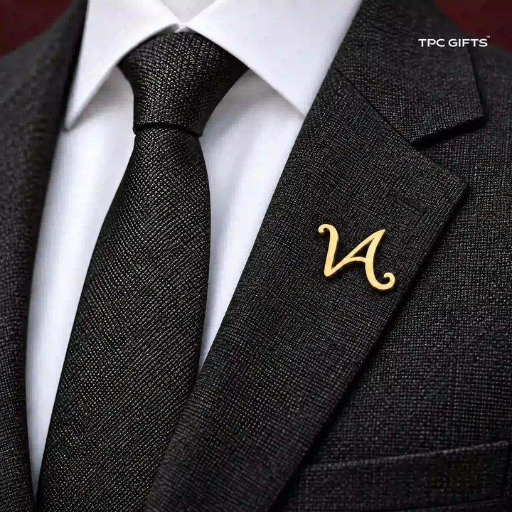 Personalised gold tone script lapel pin worn on a charcoal suit