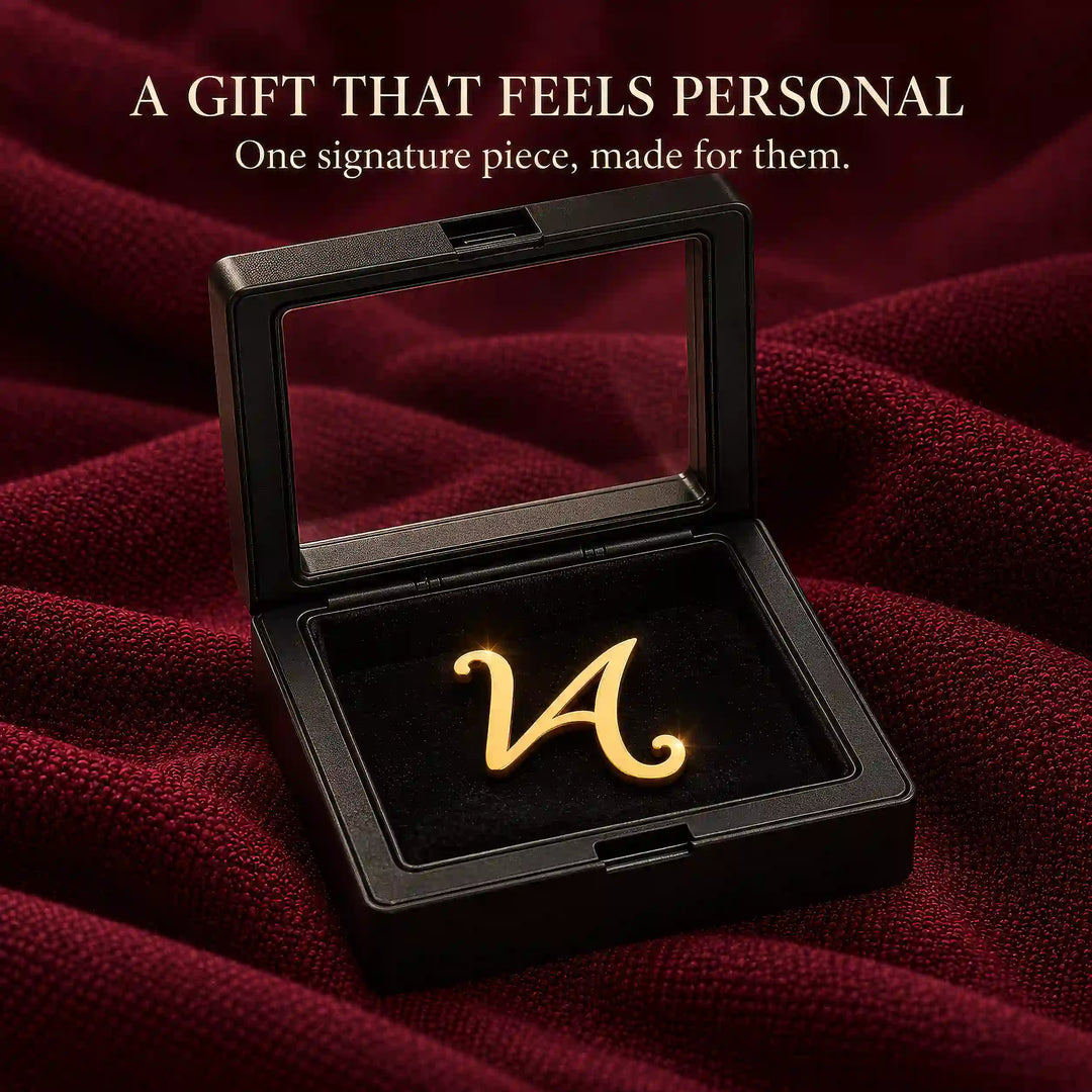 Gold tone script initial lapel pin in a black presentation box