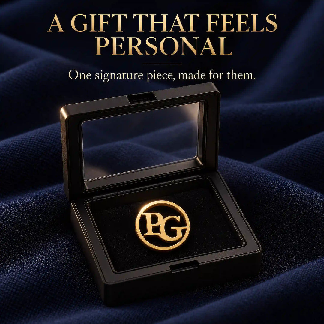 Gold tone circular two initial lapel pin in a black presentation box