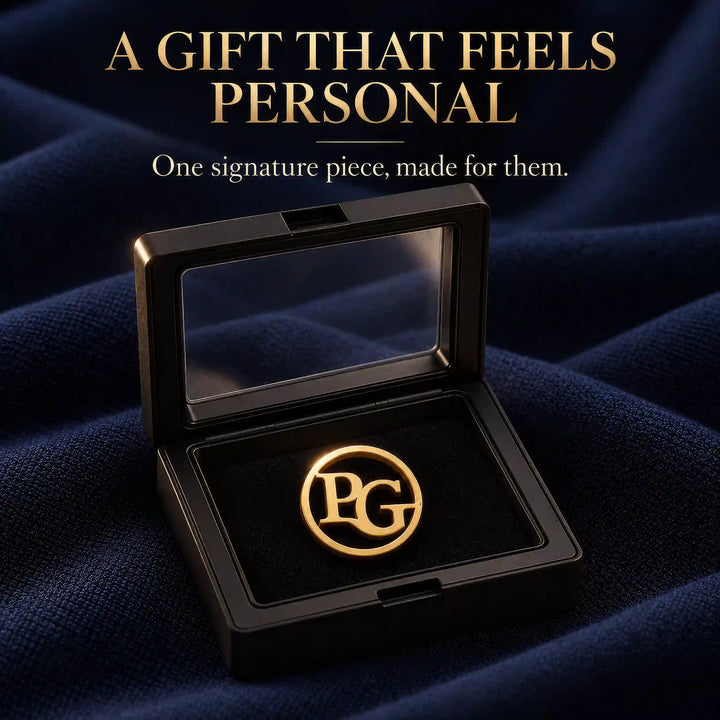 Gold tone circular two initial lapel pin in a black presentation box