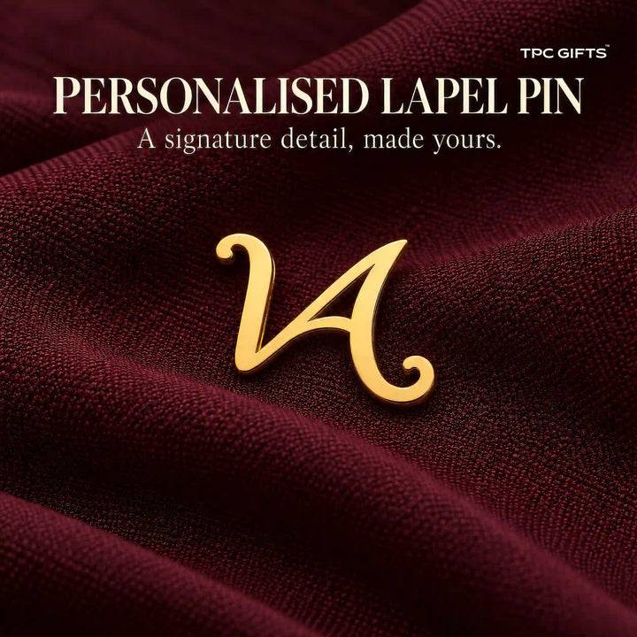 Personalised gold tone script initial lapel pin on burgundy fabric