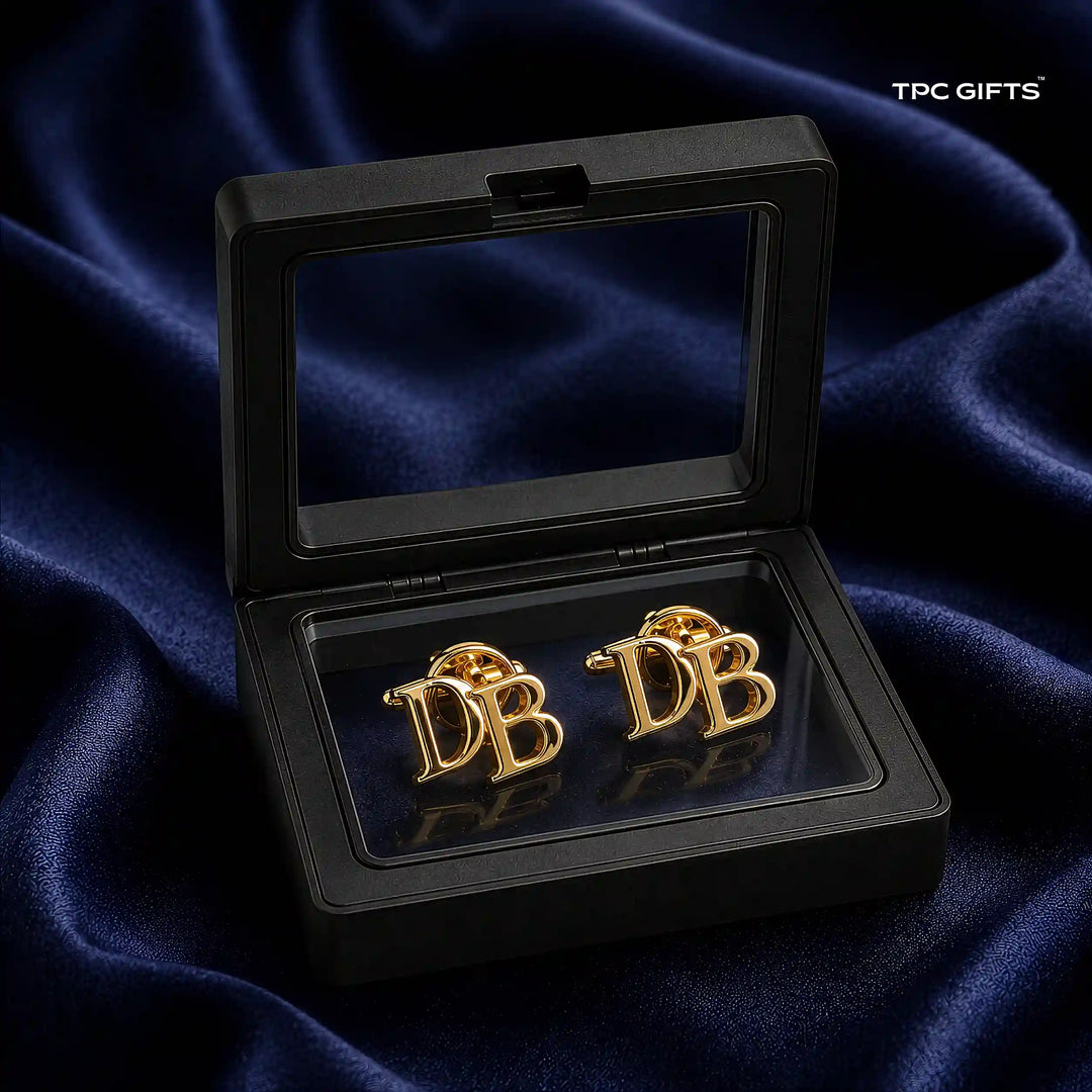 A pair of gold-toned cufflinks featuring the letters &