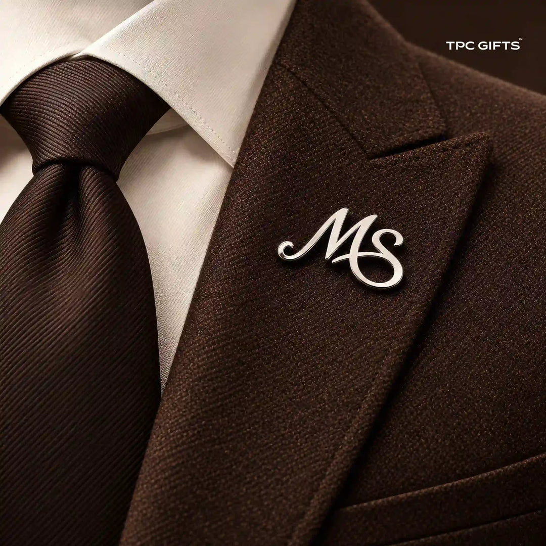Personalised silver tone two initial lapel pin worn on a brown suit