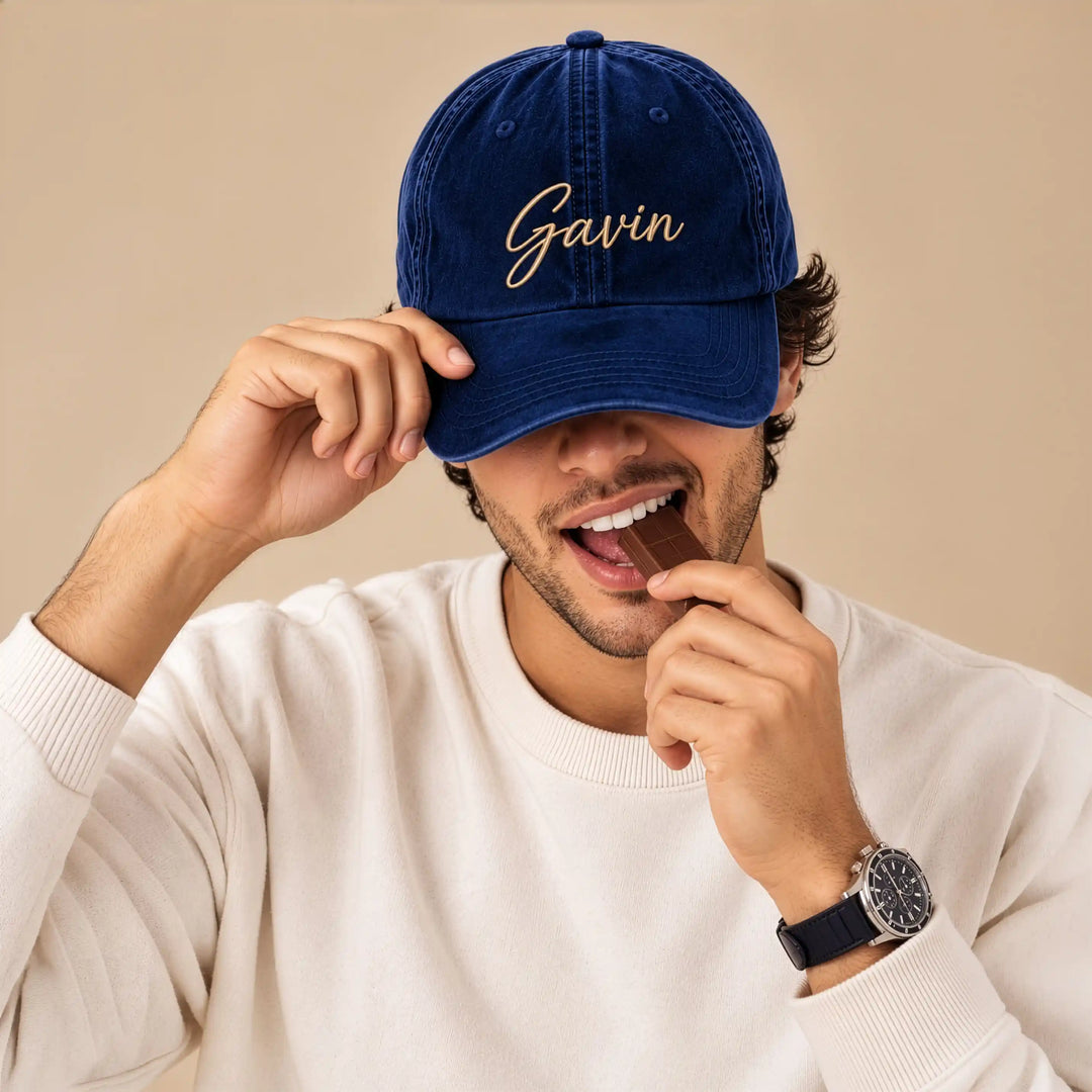 Man wearing a navy blue velvet baseball cap with the name "Gavin" embroidered in gold cursive thread