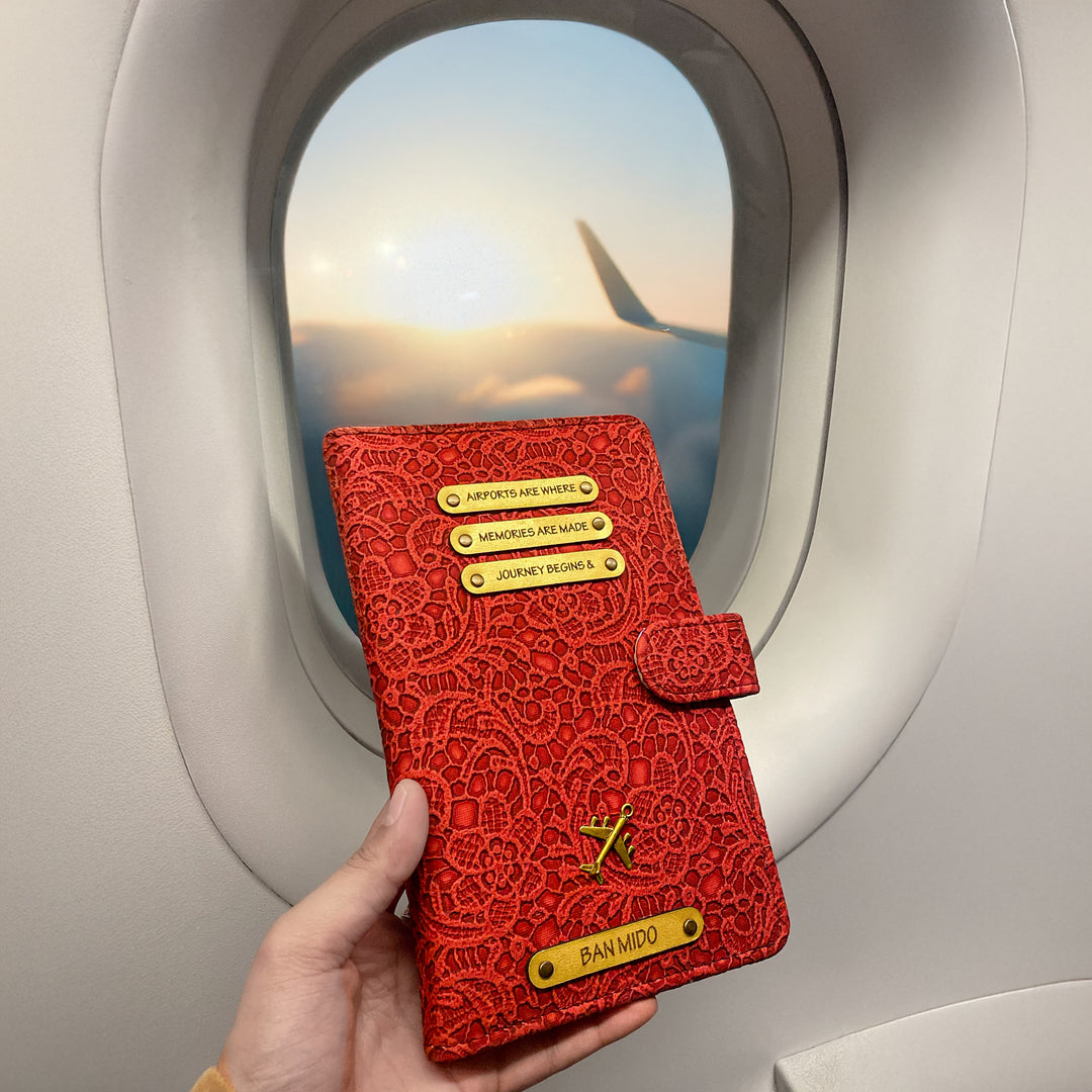 A personalized travel wallet being held by a passenger on an airplane, featuring a black leather exterior with metal accents and card slots visible through the wallet&