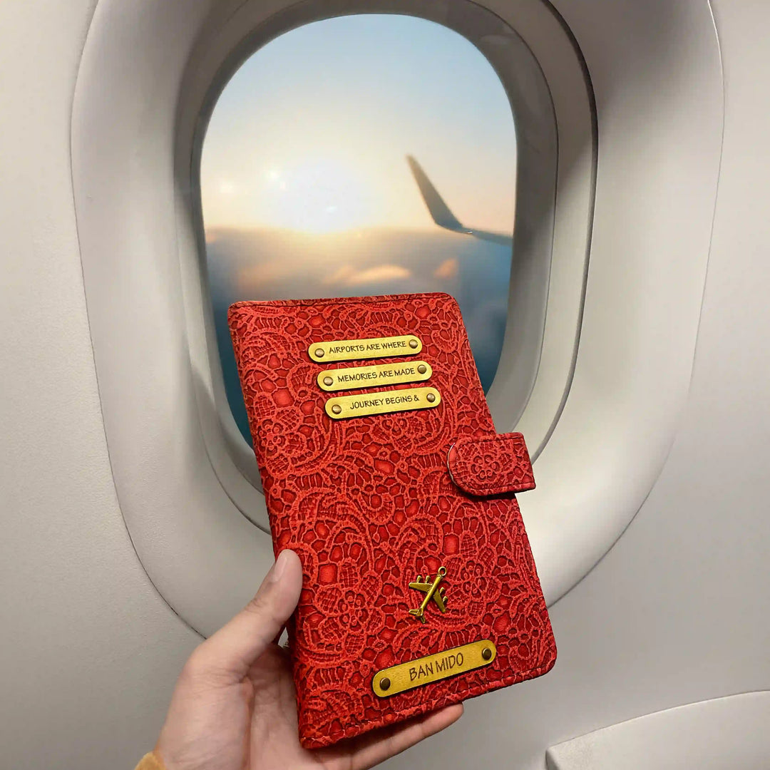 Red floral travel wallet embossed travel journal held by a hand with airplane window in background  - TPC Gifts 