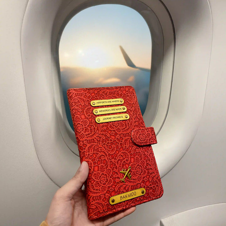 Red floral travel wallet embossed travel journal held by a hand with airplane window in background  - TPC Gifts 