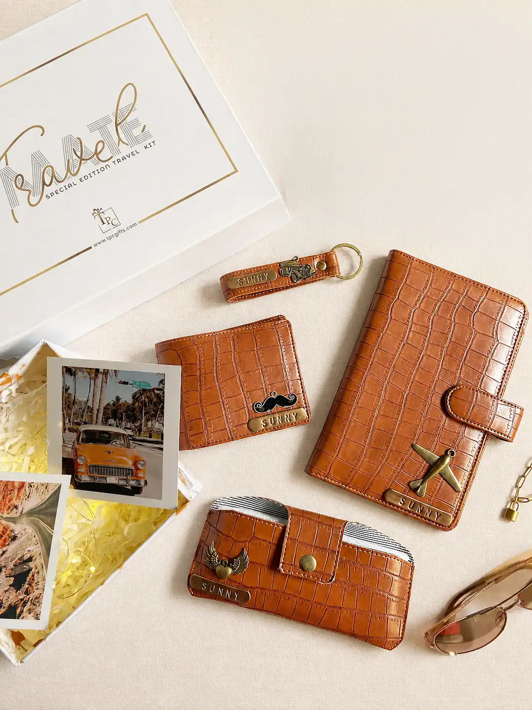 Collection of brown leather travel organiser ,money wallets,sunglass cover and keychains with decorative elements on a light background from tpc gifts