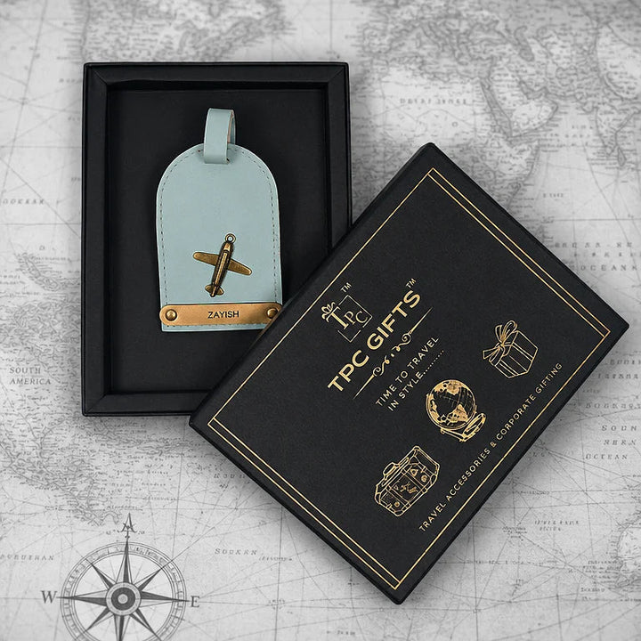 Light blue luggage tag with airplane design in a black box on a world map background