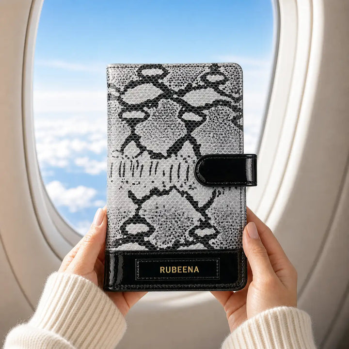 Person holding a black and white patterned genuine leather travel organiser wallet with &