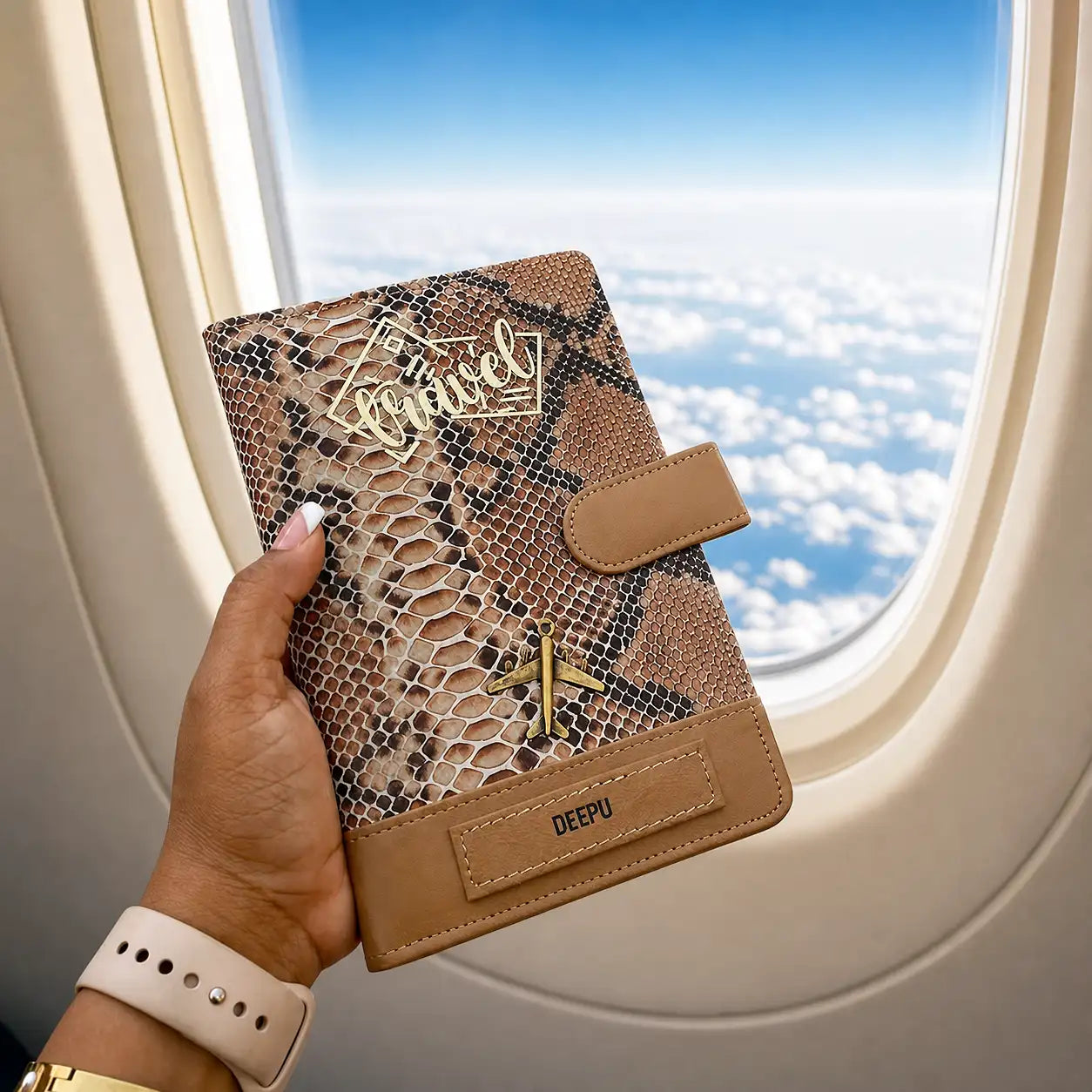 Golden lark genuine leather travel organiser wallet with name , charm and travel written on it held in hands against plane window - TPC Gifts
