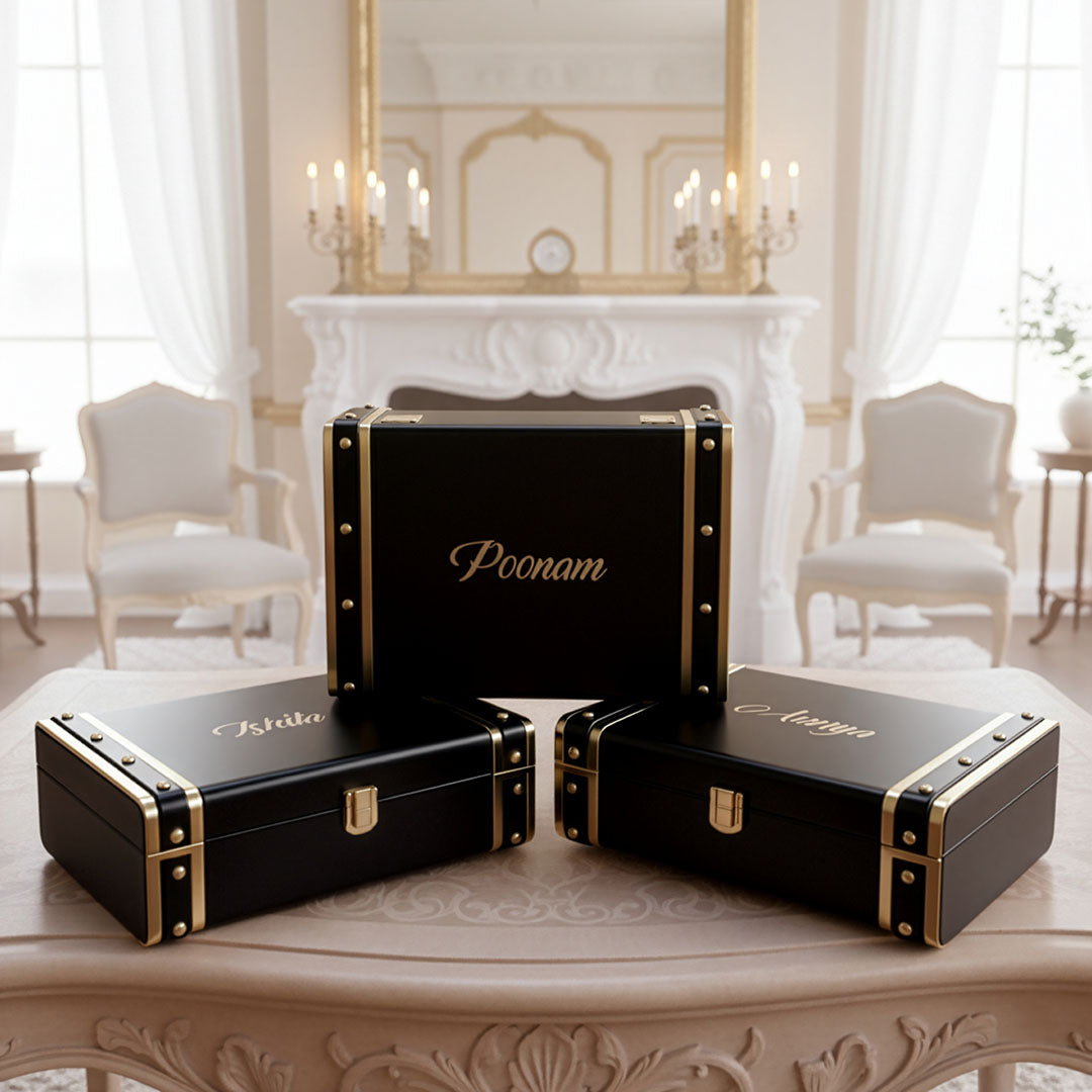 Black Trunk boxes with gold accents on a table in a elegant room by TPC Gifts
